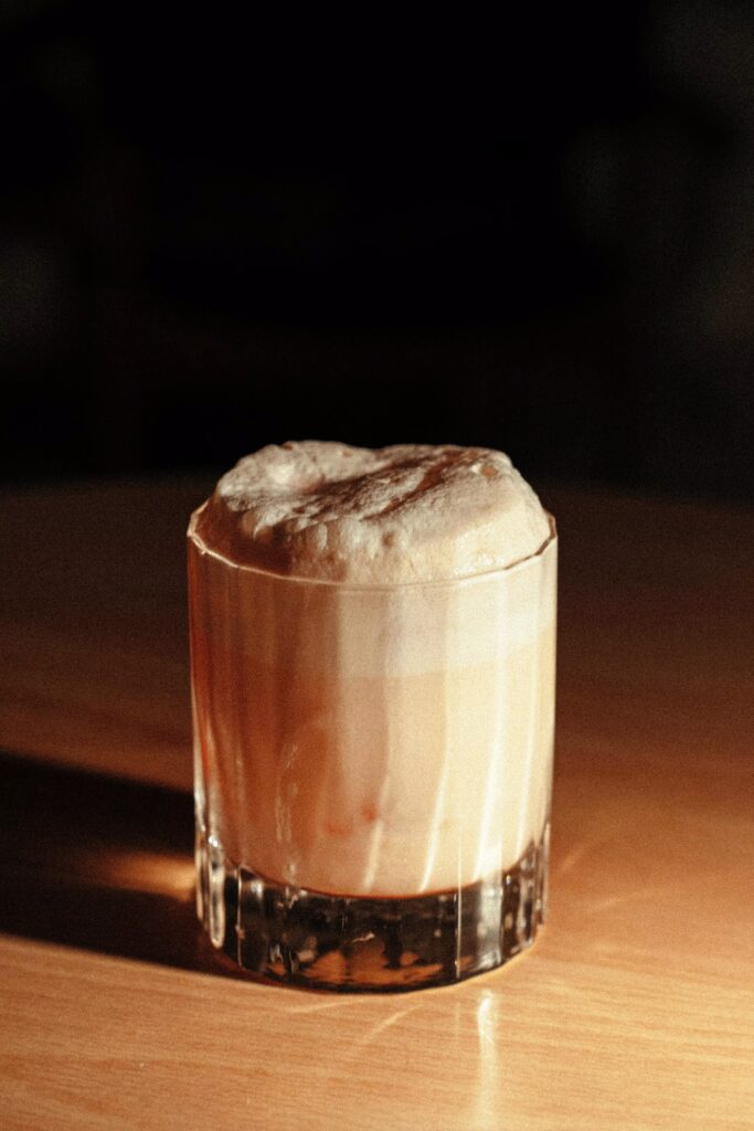 Glas met Brandy Alexander cocktail met schuimrand, populair drankje jaren 70