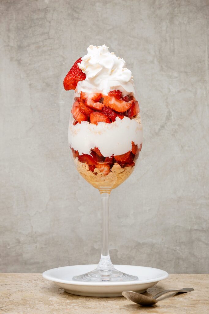 Hoog glas met aardbeien en slagroom, fruitcocktail jaren 70 dessert