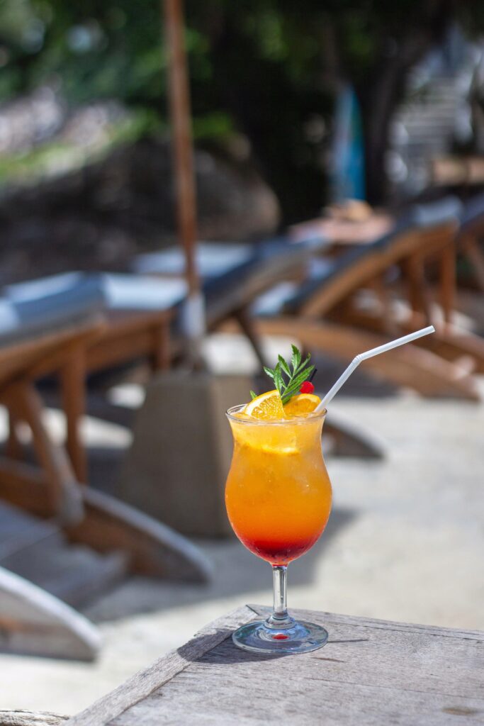 Glas met mixdrank met grenadine, afgetopt met een schijfje sinaasappel en een rietje, typisch jaren 80 cocktail.