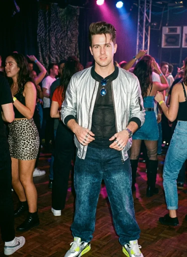 Man in glanzend bomberjack, wijde jeans en gestyled haar tijdens een midden jaren 90 feest met boyband uitstraling.