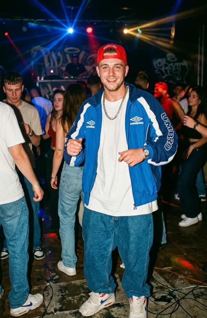 Man in oversized trainingspak, baggy jeans en sneakers tijdens een energiek midden jaren 90 feest met MTV sfeer.